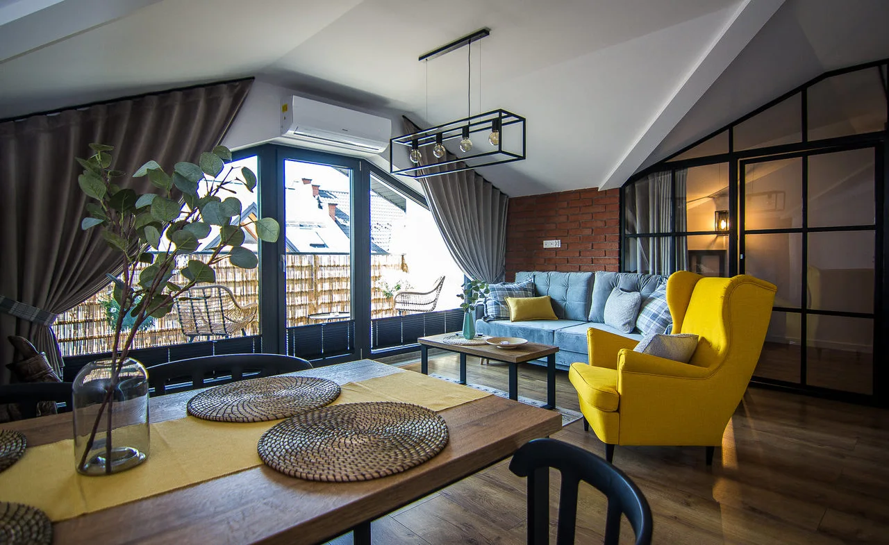 Salon apartamentu na poddaszu budynku, w którym jest gabinet